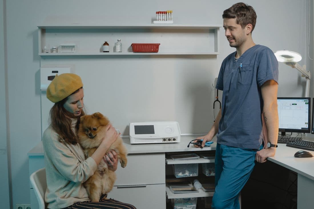 Veterinario atendiendo a una clienta con su perro